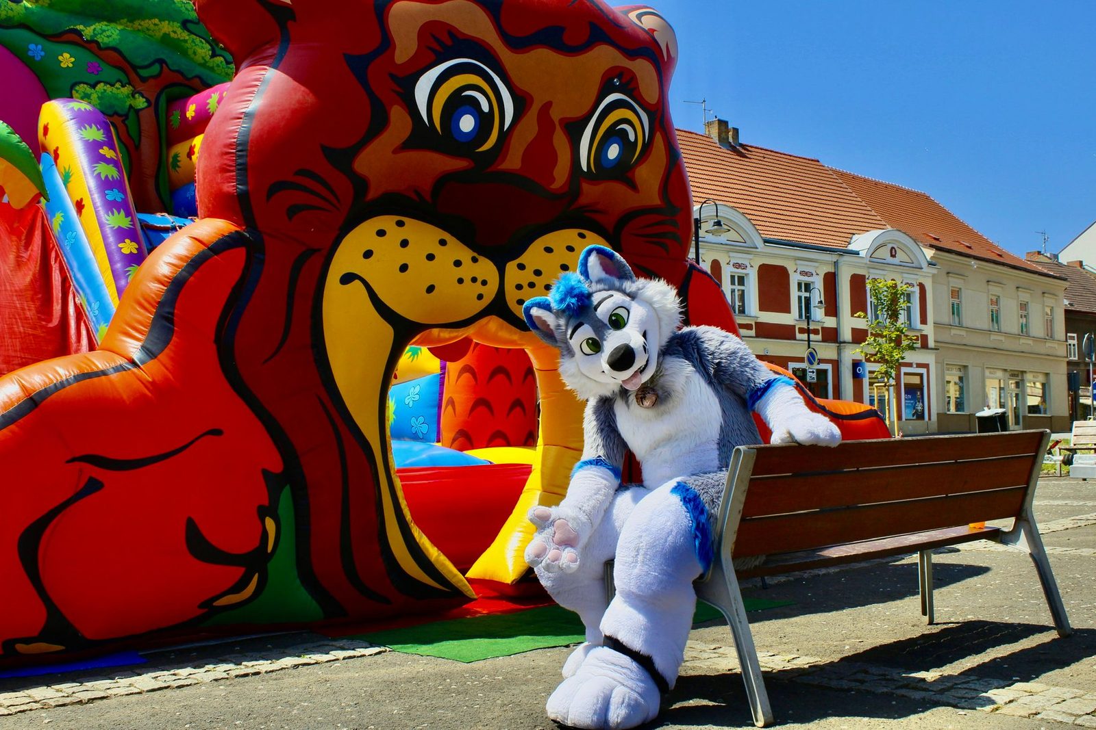 Skákací hrad a maskot na slunném náměstí